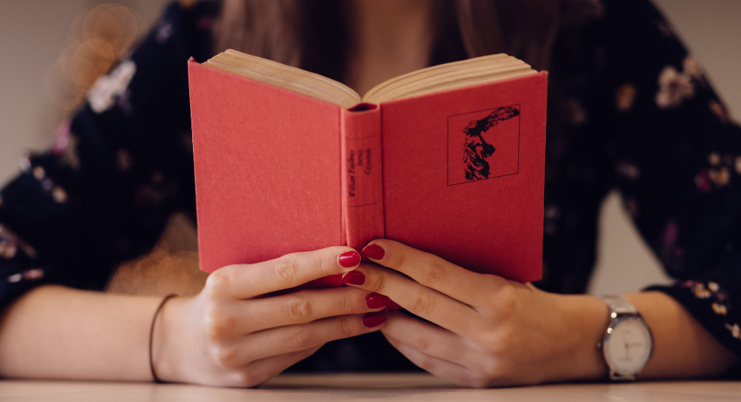 A woman holding an open book (Let's Celebrate: National Reading Across America Day Lorena Lougedo Contributor Miami Mom Collective)