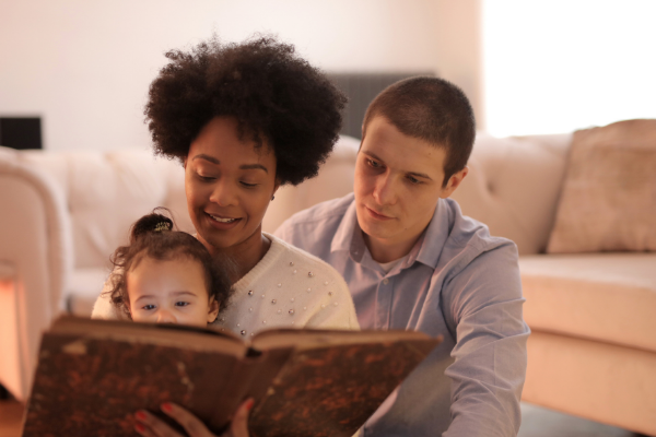 A family looking at a book together (Lorena Lougedo Contributor Miami Mom Collective)