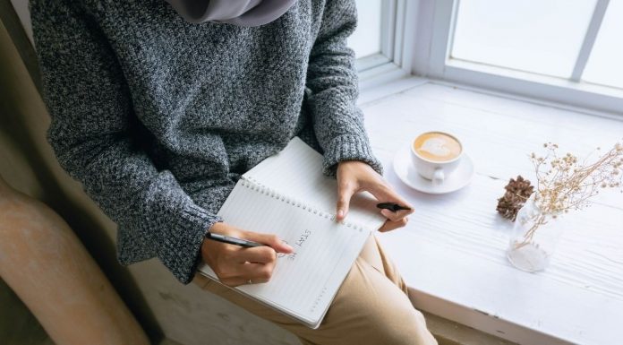 Mujer sentada y escribiendo en un diario (Me convertí en mamá y quise replantear mi profesión Karla Camacho Contributor Miami Mom Collective)