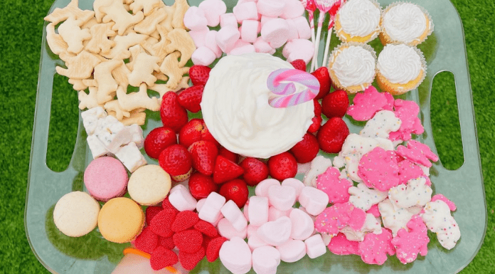 A Valentine's Day themed snack try with animal crackers, marshmallows, macarons, strawberries, and cupcakes