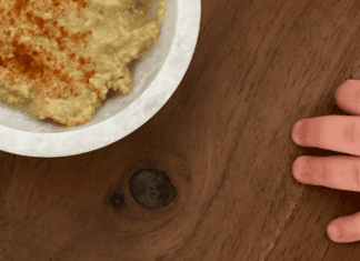 I’m a Dietitian, and I Hated Feeding My Baby Solid Food (At First) | Part 2 A toddler's hand reaching for a bowl of hummus