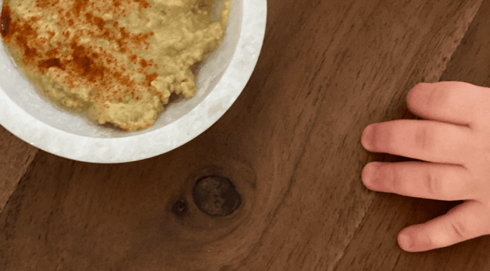 I’m a Dietitian, and I Hated Feeding My Baby Solid Food (At First) | Part 2 A toddler's hand reaching for a bowl of hummus