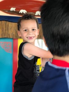 Image: A little boy smiling and showing off his missing front teeth