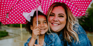 Image: A mother and daughter share smiles and an umbrella
