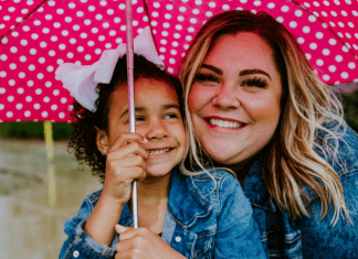 Image: A mother and daughter share smiles and an umbrella