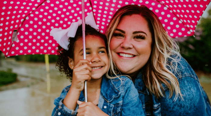 National Adoption Month: Adopting Children From Foster Care Image: A mother and daughter share smiles and an umbrella