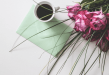 Breastfeeding Past Infancy: An Open Letter to Moms Image: A sealed envelope on a table with a cup of coffee and bouquet of roses