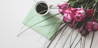Breastfeeding Past Infancy: An Open Letter to Moms Image: A sealed envelope on a table with a cup of coffee and bouquet of roses