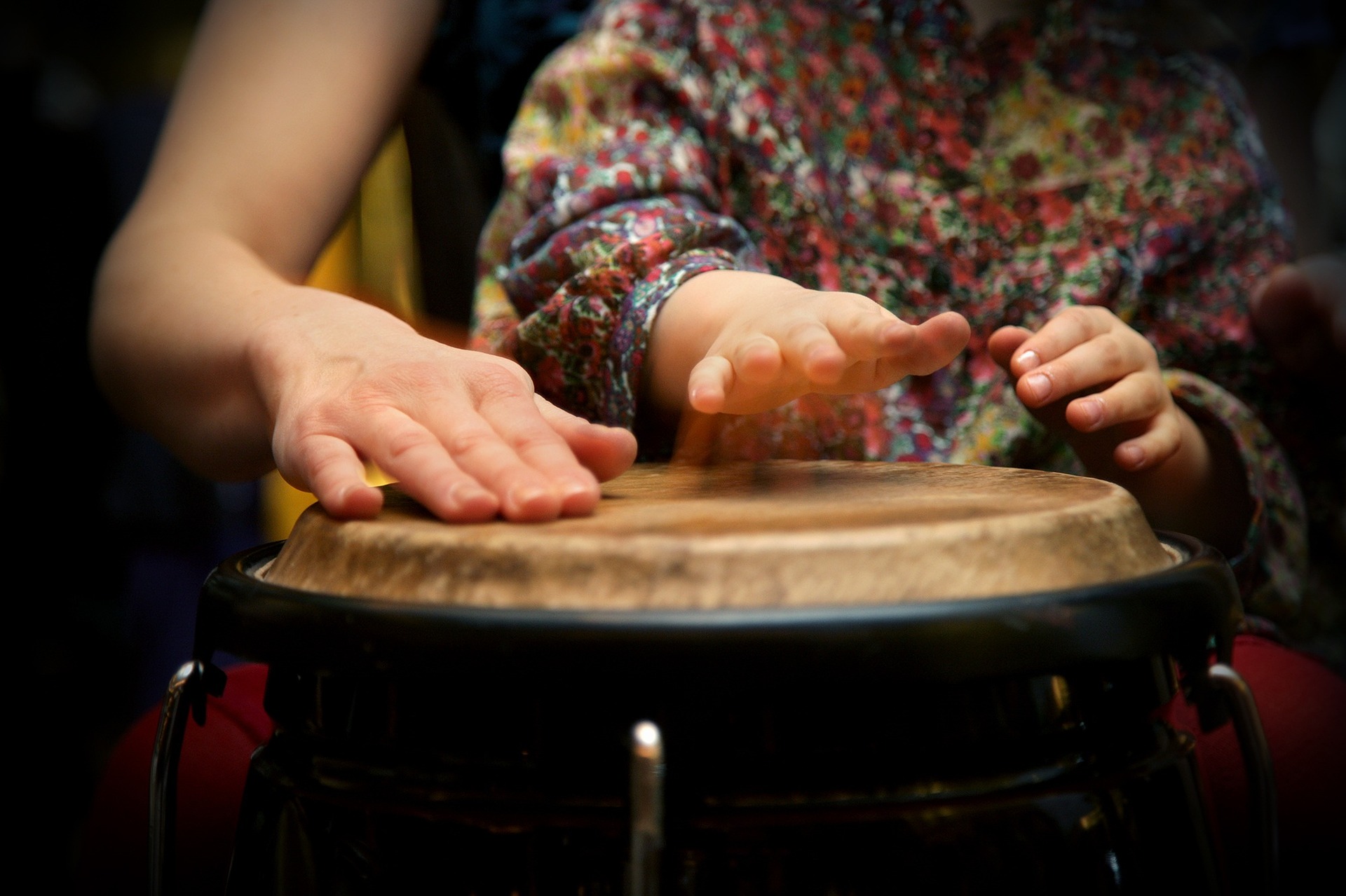 Image: A parent plays a bongo with their young child