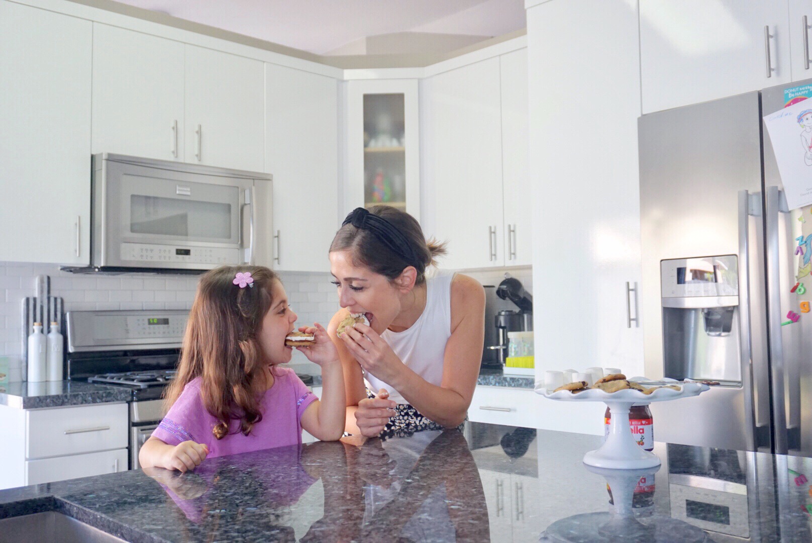 Image: A mother and daughter enjoy homemade chocolate chip cookie s'mores together