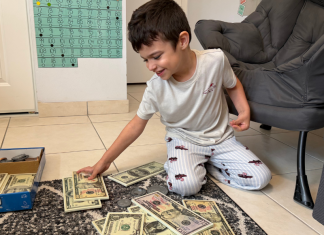 Image: A child engaging in a money-themed home learning activity
