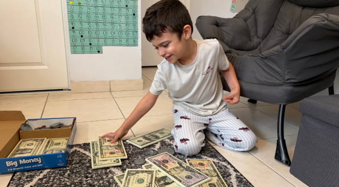 Homeschooling My Neurodivergent Child: What’s Working For Us Image: A child engaging in a money-themed home learning activity