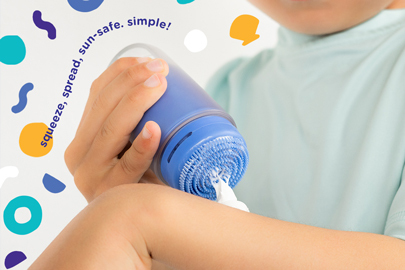 Image: A young child applies Ubbi Sunsqueeze sunscreen to their forearm