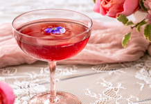 pink brunch cocktail with flowers in background