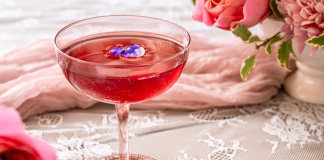 pink brunch cocktail with flowers in background