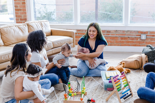 Group of women with babies playing on the floor 
