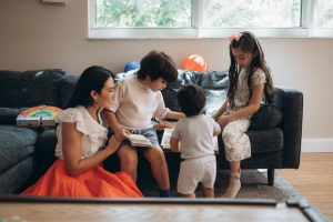 mom and three children looking at photos in the living room