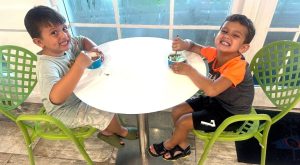 Image: Two children enjoy a snack indoors