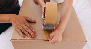 Image: A child helps a parent tape a moving box closed
