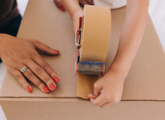 Image: A child helps a parent tape a moving box closed