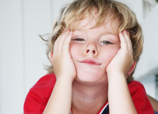 Little boy with hands on his face who appears bored