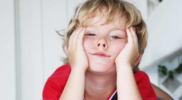 Little boy with hands on his face who appears bored
