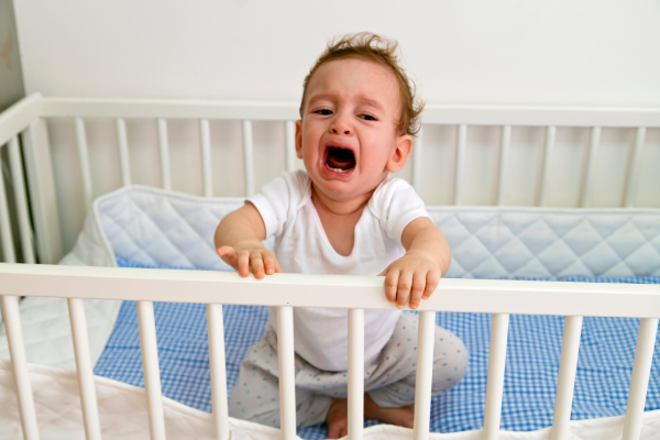 Image: A toddler cries to get out of their crib