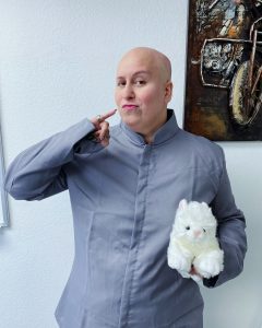 Image: Jackie dressed up as Dr. Evil from Austin Powers and holding a stuffed white dog for Halloween