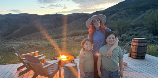 This Summer: What I’m Not Doing as a Mom Image: A mom poses for a photo with her kids in front of a campfire