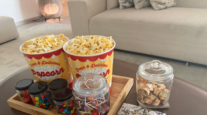 Image: A tray of popcorn and other movie snacks on a living room coffee table