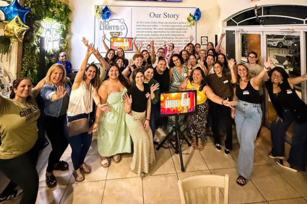 A group of special needs moms are gathered around a karaoke screen for a fun night out.
