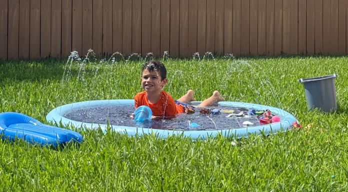 Neurodivergent Families: 3 Summer Survival Tips Image: A young child enjoys a splash pad in the backyard