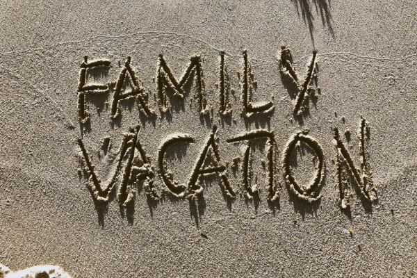 The words family vacation written in the sand