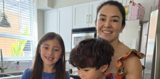 Image: A candid photo of a mother in the kitchen with her children