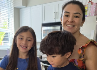 Image: A candid photo of a mother in the kitchen with her children