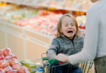 Toddler crying in a shopping cart in the produce section
