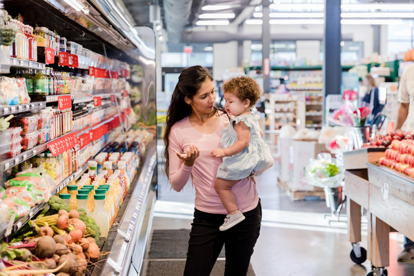 Woman carrying toddler in a supermarket